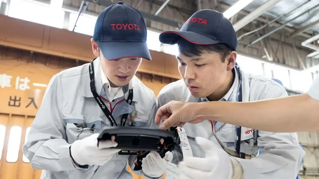 کارکنان تویوتا (Toyota) در حال بازرسی دقیق یک قطعه خودرو در خط تولید